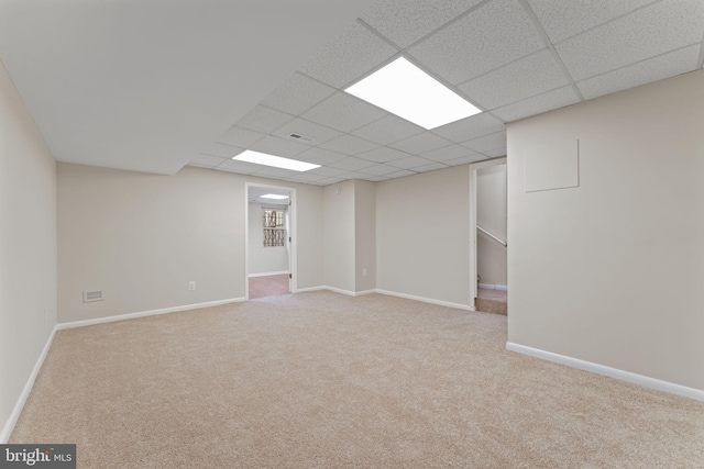 basement featuring light carpet and a drop ceiling