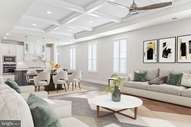 living room featuring beam ceiling, ceiling fan, coffered ceiling, and ornamental molding