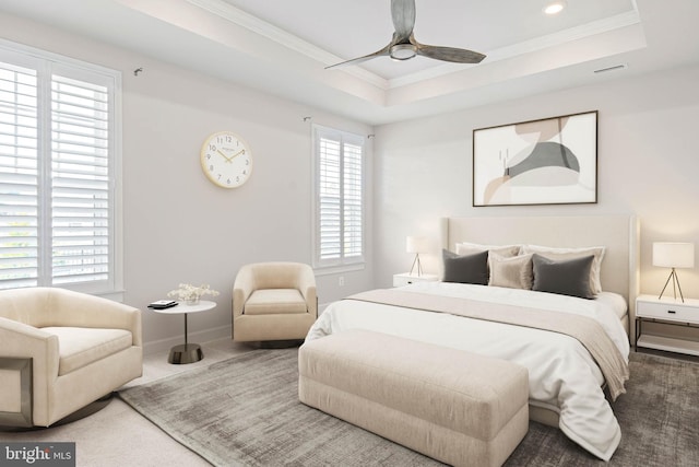 carpeted bedroom featuring ceiling fan, multiple windows, ornamental molding, and a raised ceiling