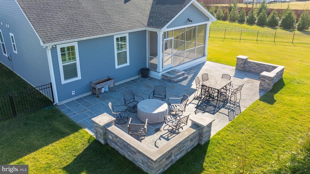 rear view of house featuring a patio area, a sunroom, and a yard