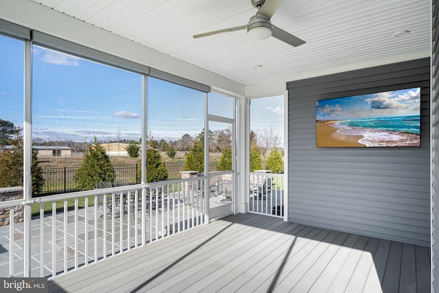 unfurnished sunroom featuring ceiling fan