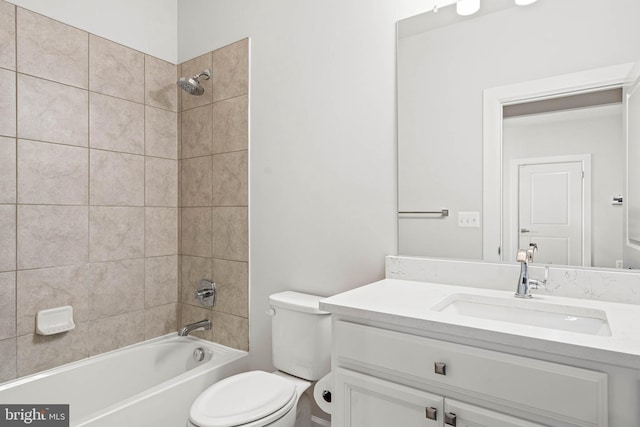 full bathroom featuring toilet, tiled shower / bath, and vanity