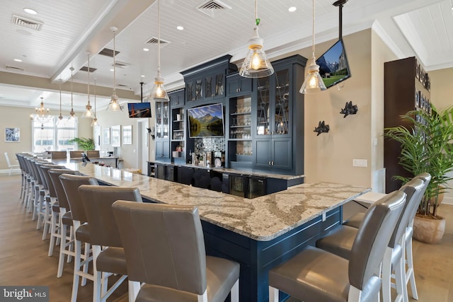 bar with decorative light fixtures, light stone countertops, light hardwood / wood-style floors, and wood ceiling