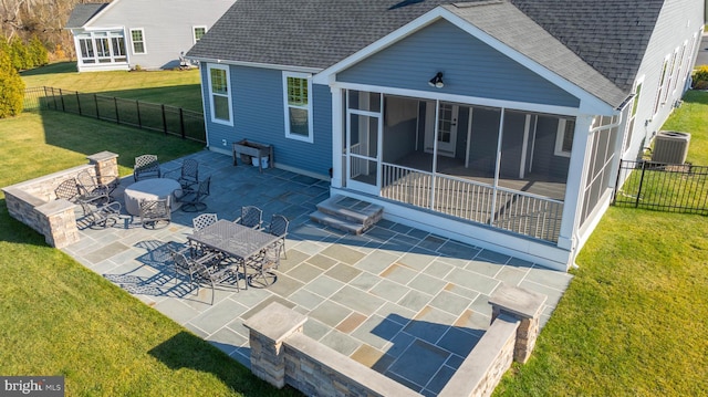 back of house with a lawn, a sunroom, and a patio