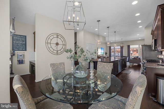 dining area featuring dark hardwood / wood-style floors, sink, and a chandelier