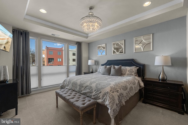 carpeted bedroom featuring a chandelier, a tray ceiling, and ornamental molding