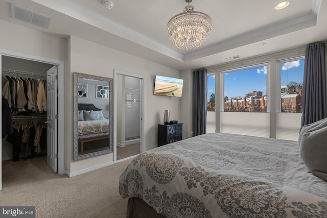 carpeted bedroom featuring a raised ceiling, a chandelier, and ornamental molding