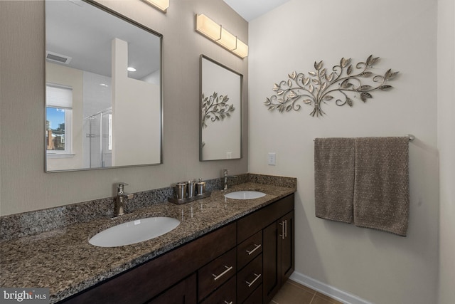 bathroom featuring tile patterned flooring, vanity, and a shower with door