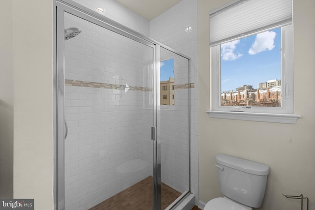 bathroom featuring toilet and an enclosed shower