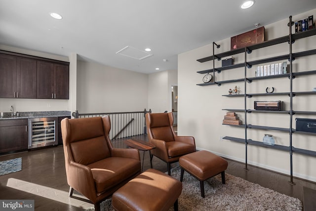 sitting room with dark hardwood / wood-style floors, beverage cooler, and sink