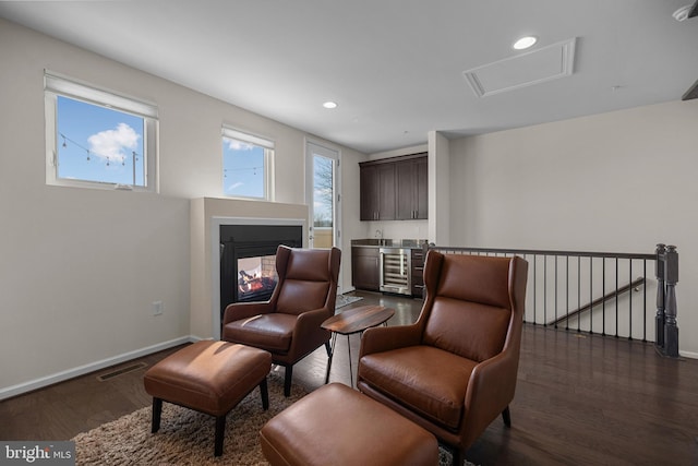 living area featuring wine cooler and dark wood-type flooring