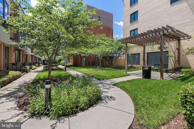 view of community featuring a pergola and a yard