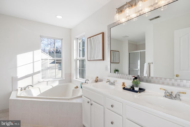 bathroom featuring vanity and shower with separate bathtub