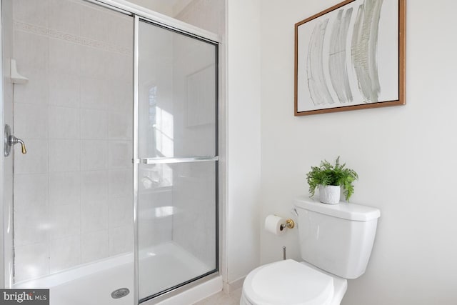 bathroom featuring an enclosed shower and toilet