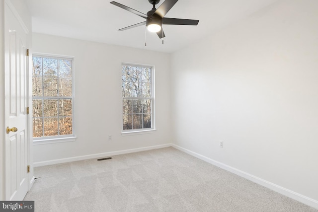 spare room featuring plenty of natural light, light carpet, and ceiling fan