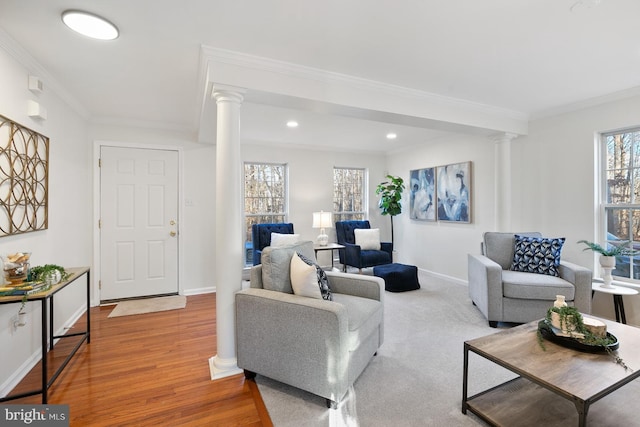 living room featuring decorative columns, ornamental molding, and hardwood / wood-style floors