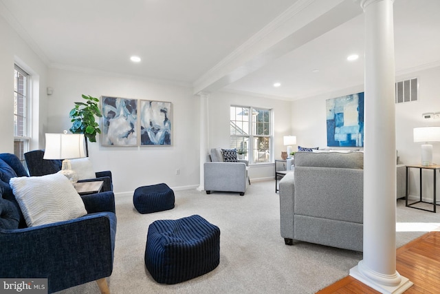 carpeted living room featuring crown molding and decorative columns