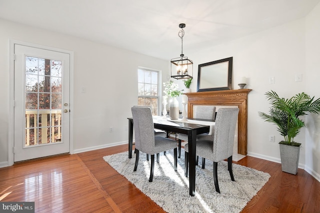 dining area with hardwood / wood-style flooring and an inviting chandelier