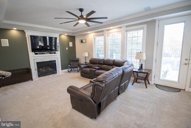 living room featuring ceiling fan, light colored carpet, ornamental molding, and a premium fireplace