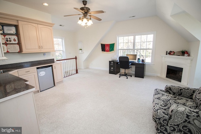 carpeted home office featuring ceiling fan, sink, a healthy amount of sunlight, and vaulted ceiling