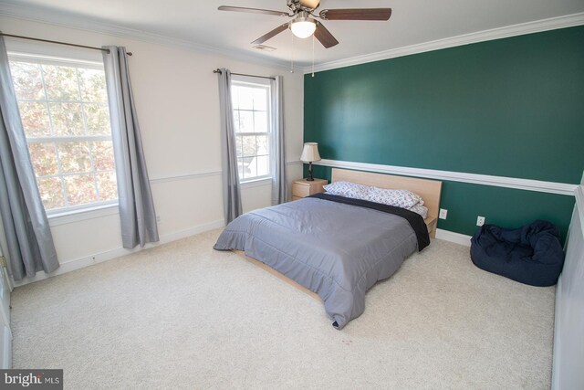 carpeted bedroom with ceiling fan, crown molding, and multiple windows