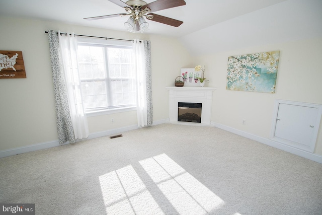 unfurnished living room featuring ceiling fan, lofted ceiling, and light carpet