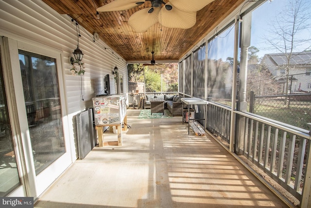 unfurnished sunroom featuring ceiling fan and wood ceiling