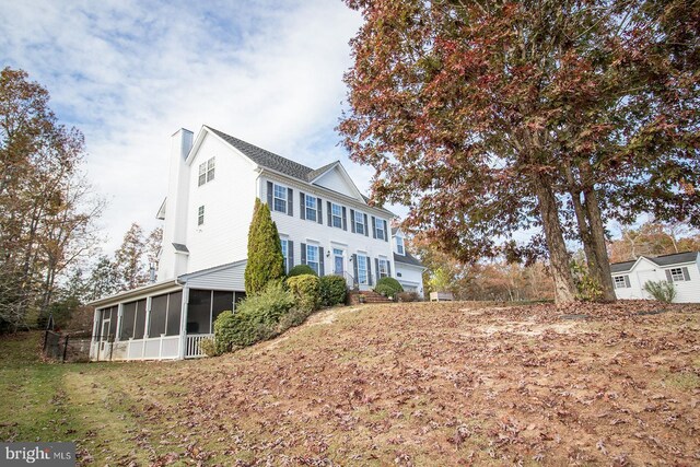 view of side of property featuring a sunroom