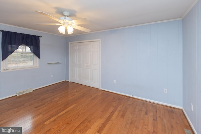 spare room featuring crown molding, ceiling fan, and wood-type flooring