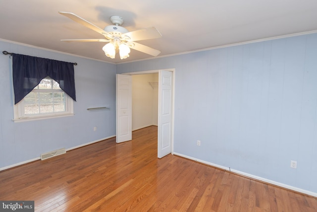 unfurnished room with ceiling fan, ornamental molding, and wood-type flooring