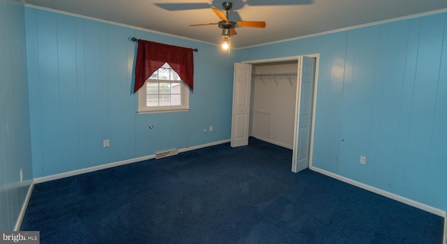 unfurnished bedroom featuring dark colored carpet, ornamental molding, ceiling fan, and a closet