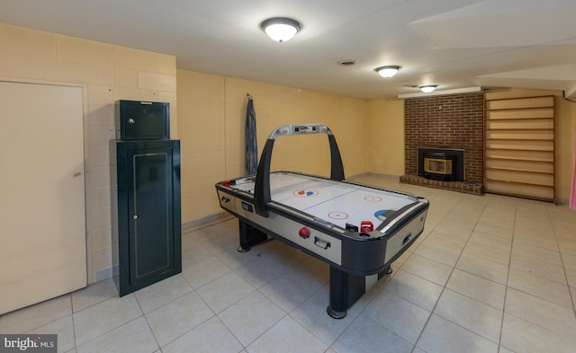 playroom with a brick fireplace and light tile patterned floors