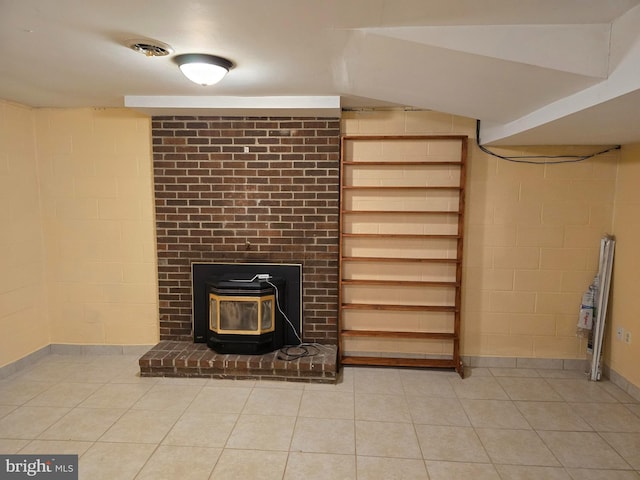 interior space featuring tile patterned flooring and a wood stove