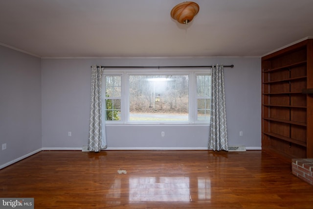 empty room with crown molding and dark wood-type flooring