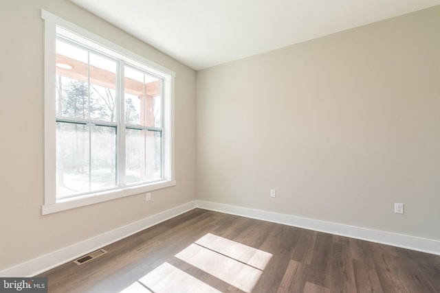 unfurnished room with dark hardwood / wood-style flooring and a wealth of natural light