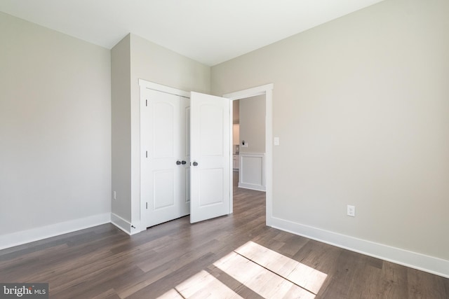 unfurnished bedroom with dark wood-type flooring