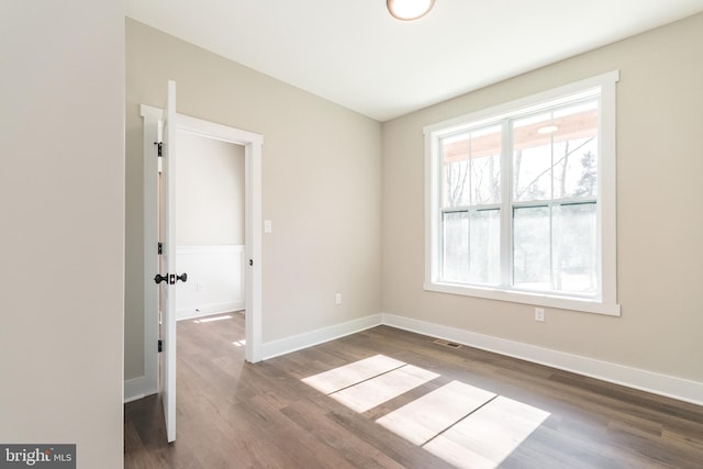 empty room with dark hardwood / wood-style flooring