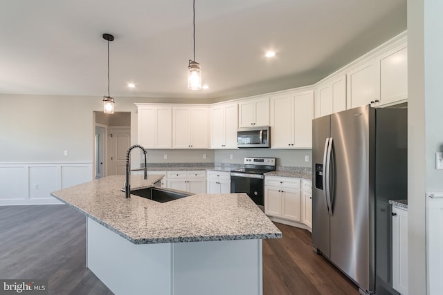 kitchen featuring dark hardwood / wood-style flooring, stainless steel appliances, sink, white cabinetry, and an island with sink