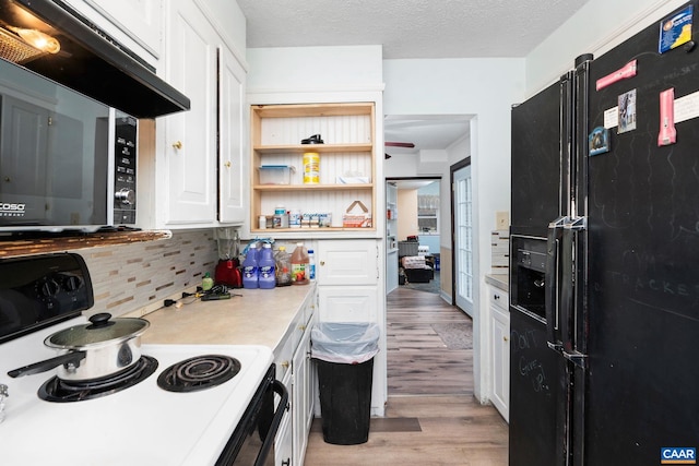 kitchen featuring decorative backsplash, a textured ceiling, black appliances, light hardwood / wood-style flooring, and white cabinetry