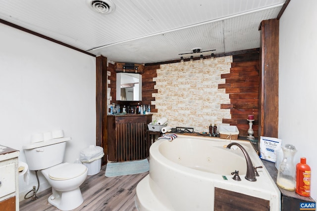 bathroom featuring vanity, wooden walls, a washtub, toilet, and wood-type flooring