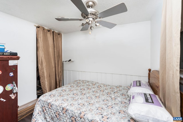 bedroom with ceiling fan and a textured ceiling