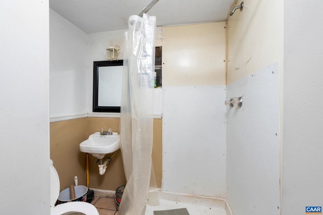 bathroom featuring walk in shower, sink, tile patterned flooring, and toilet