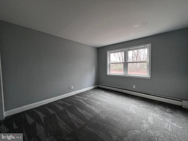 carpeted spare room with a baseboard radiator