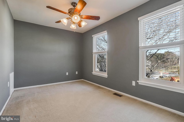 carpeted spare room with ceiling fan