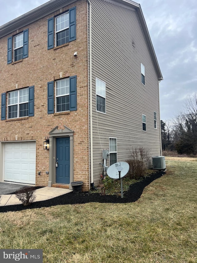 view of front of home with a front yard, a garage, and cooling unit