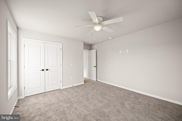 unfurnished bedroom featuring ceiling fan, a closet, and carpet floors