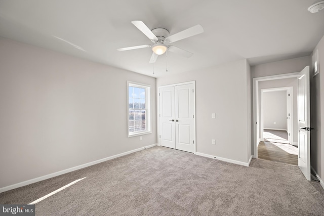 unfurnished bedroom with ceiling fan, a closet, and carpet