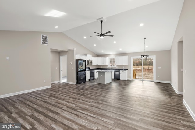 kitchen with dark hardwood / wood-style flooring, a center island, white cabinets, and appliances with stainless steel finishes