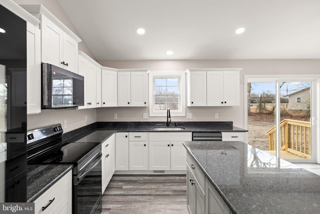 kitchen with dark wood-type flooring, sink, black appliances, dark stone countertops, and white cabinets