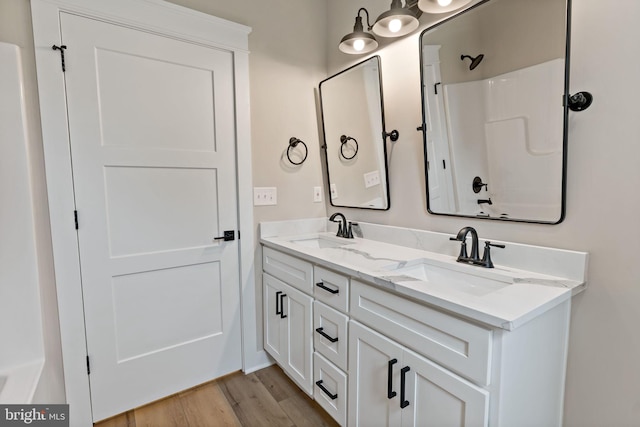 bathroom featuring hardwood / wood-style floors, vanity, and shower / bathtub combination